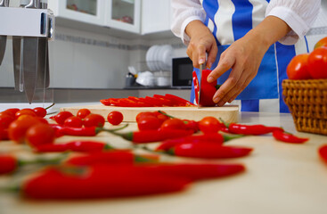 Chef cuts the vegetables into a meal. Preparing dishes. A woman uses a knife and cooks.