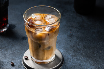 Iced coffee in a tall glass with cream poured over. Iced latte. Cold summer drink. Cold brew in glass. Cappuccino on Ice. Vietnamese Iced Coffee.