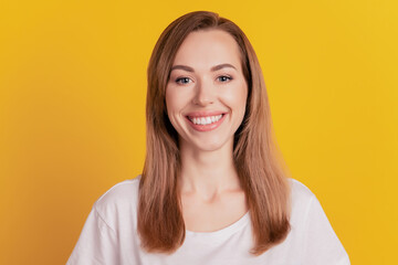 Close-up of a woman shiny white smiling look camera on yellow background