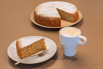 Old recipe cake made from almonds and dry bread (Antica torta alle mandorle e pane) with a cup of cappuccino