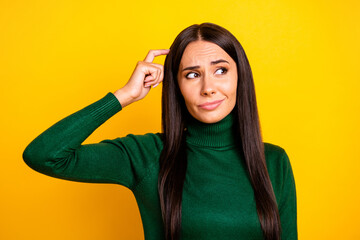 Photo of young unhappy upset thoughtful doubtful girl look copyspace thinking isolated on yellow...