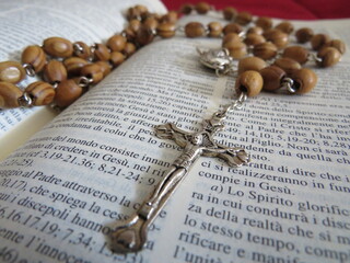 Rosario e crocifisso sopra una pagina della bibbia - Rosary and crucifix over a bible page