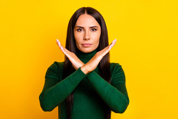 Photo of young beautiful serious businesswoman showing stop no sign prohibition isolated on yellow...