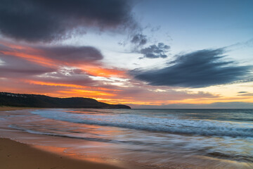 Naklejka na ściany i meble Sunrise at the seaside with pastel coloured clouds