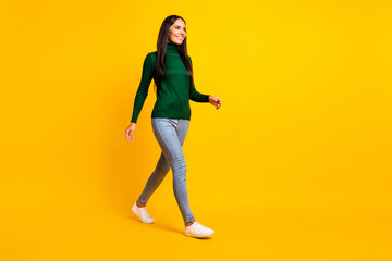 Fototapeta na wymiar Full size profile side photo of young charming lovely positive girl go walk look copyspace isolated on yellow color background