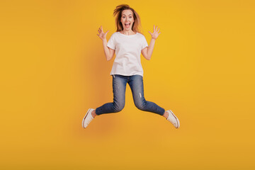 Fototapeta na wymiar Photo of charming nice positive girl jumping open mouth on yellow background