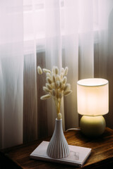 A vase of dried flowers on the table. Beige color