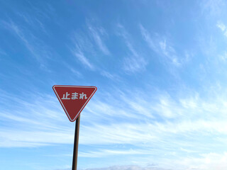 止まれの道路標識と青空