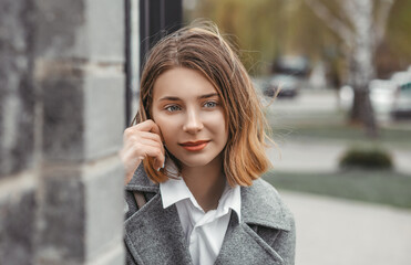 Face portrait of attractive young woman in gray coat