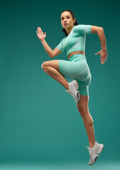 Sporty young woman jumping in the air - obrazy, fototapety, plakaty