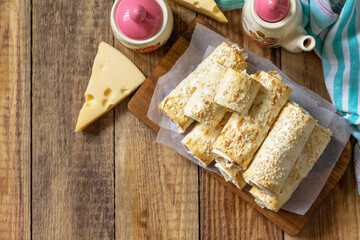 Breakfast, picnic, lunch or snack concept. Lavash roll with cottage cheese, cheese and spinach on a rustic table. Top view, flat lay. Copy space.