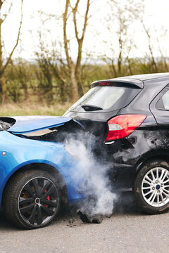 Two Damaged Cars Involved In Road Traffic Accident Showing Smoke After Collision