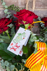 Tarragona, Spain - April 28, 2021: Roses with a dragon card to celebrate Sant Jordi day, the day of the book and the rose in Catalonia.