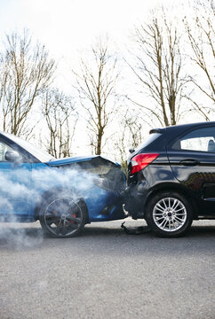 Two Damaged Cars Involved In Road Traffic Accident Showing Smoke After Collision