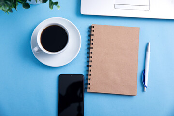 computer with notepad and coffee on table