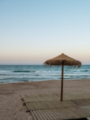 Boardwalk with an umbrella next to a fishing rod