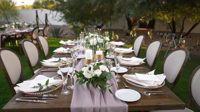 Stylish Outdoor Dinner Party. Decorated Table with beautiful flower bouquets. 