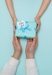 Fototapeta na wymiar Happy father's day. Gift in the hands of daughter and father on a blue background. vertically