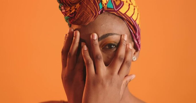 A black girl hides her face because of self-doubt. Face close up. Expressive square eye.