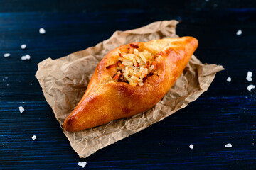 russian pie rasstegay with a hole on top, Traditional Russian, Slavic pies with hole in center. Rasstegay on wooden background © smspsy