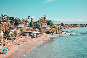 Mediterranean sea beach landscape with turquoise water and blue sun loungers on the sand