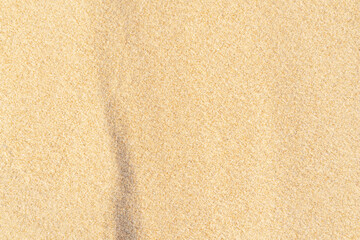 Sand texture background on the beach. Light beige sea sand texture pattern.