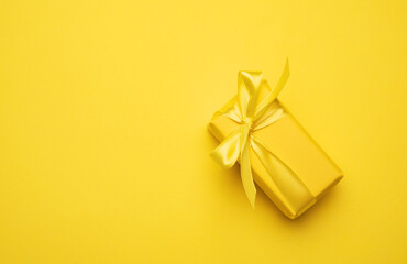 yellow rectangular box with a gift wrapped in yellow paper