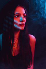 Portrait of beautiful girl in a hat with a red blue neon light