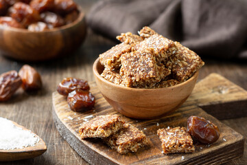 Coconut cookies with dates and carrots in a wooden bowl on a brown background closeup. The concept of a healthy snack no sugar