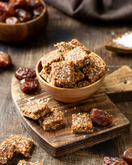 Coconut cookies with dates and carrots in a wooden bowl on a brown background closeup. The concept of a healthy snack no sugar