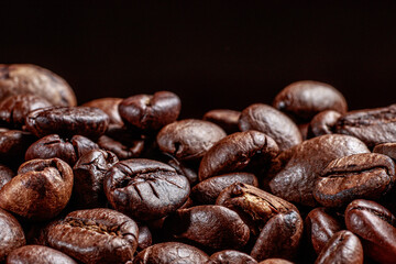 A breathtaking photo of coffee beans on a black background. Horizontal banner with place for text for advertising or offer of a coffee shop