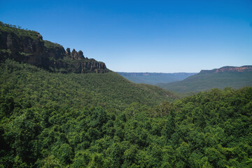 View into green forest valley with the rock formation 'Three Sisters' in the Blue Mountains, Australia