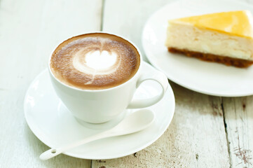 Latte coffee with New York cheesecake background.