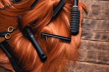 Naklejka premium Hairdressing salon concept background. Redhead women wig and combs on the hairdresser table flat lay background.