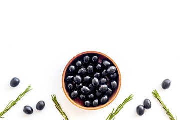 Wooden bowl with black olives. Overhead view, space for text
