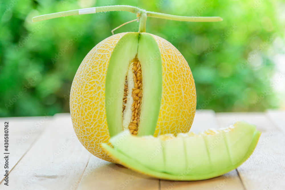 Wall mural closeup to fresh yellow galia melon on wood plate