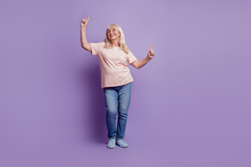 Mature crazy grey haired lady dancing on purple background