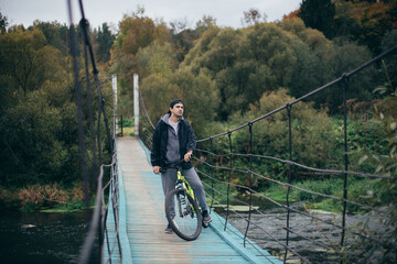 A man on a bicycle in the autumn on the bridge.