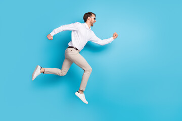 Fototapeta na wymiar Full size profile side photo of happy amazed young man run jump up empty space sale isolated on blue color background