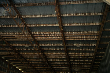 A Grid metal and wood interior roof in a shed or old building.
