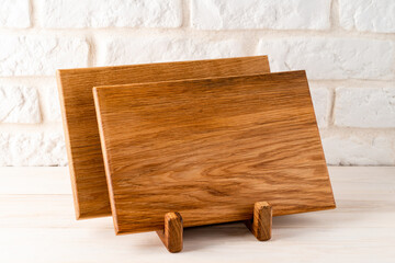 Background kitchen with cutting board on white wooden table and against the background a brick wall