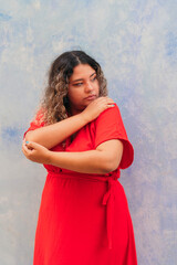 Beautiful plus size woman in dress standing against the blue wall