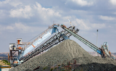 Mining equipment and an escalator over rock dumps at  diamond mine.