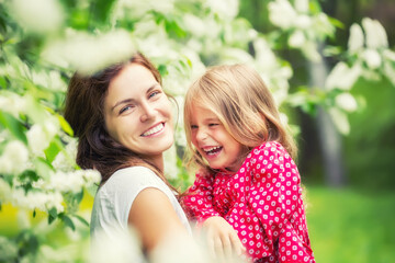 Fototapeta premium Portrait of happy mother and little daughter in spring park