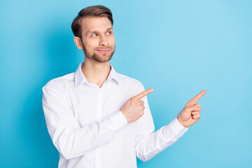 Portrait of attractive cheerful guy demonstrating copy space place ad advert isolated over bright blue color background