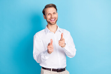 Photo of happy cheerful attractive young man point fingers you choose good mood isolated on blue color background