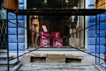 Building structures in front of a glass shop window.