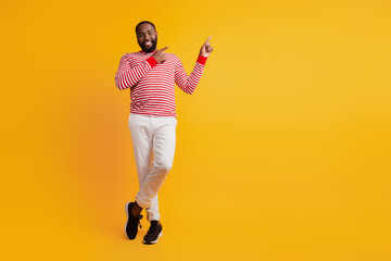Photo of african guy direct forefinger empty space on yellow background
