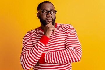 Obraz premium Photo of minded pensive african guy serious face wear glasses on yellow background