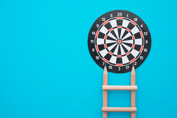Pencil ladder and dartboard with blue background. Education or business growth for successful...